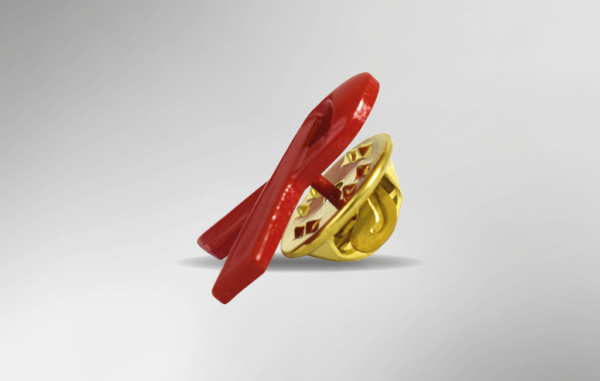 Seitenansicht der roten AIDS-Schleife. Sie ist eine Brosche und hat hinten einen goldenen Pin.